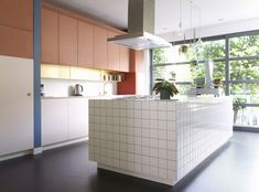 a large kitchen with an island in front of a window and potted plant on the counter