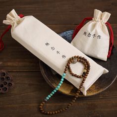 a couple of beads sitting on top of a plate next to a bag with a ring