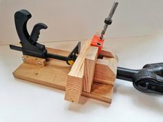 a pair of tools is sitting on top of a piece of wood that has been made into a clamp