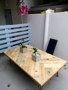 a wooden table with two planters on it