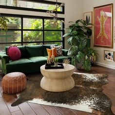 a living room filled with lots of furniture and decor on top of a hard wood floor