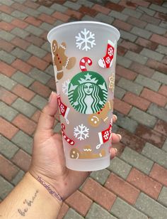 someone holding up a starbucks cup with christmas decorations on it