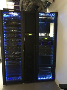 two tall black racks with blue lights in the front and back of them, next to each other