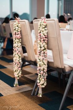 the chairs are decorated with pink and white flower garlands for an elegant wedding reception