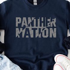 a t - shirt with the word panther nation printed on it next to some shoes