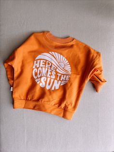 An oversized sweat with organic two yarn fabric 'Here Comes The Sun' motto backside printed Beautiful Orange fabric  Cute & Stylish Oversize Sweat Relax & Cute gift Washed at a maximum of 30 degrees Orange Relaxed Fit Sporty Sweatshirt, Oversized Letter Print Sweats For Everyday, Organic Cotton Long Sleeve Sweatshirt With Letter Print, Oversized Orange Tops With Letter Print, Oversized Cotton Sweats With Text Print, Oversized Orange Top With Letter Print, Long Sleeve Organic Cotton Sweatshirt With Letter Print, Relaxed Fit Orange Sweatshirt With Graphic Print, Orange Cotton Sweatshirt With Relaxed Fit