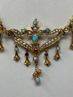 "Antique Art Nouveau 9Kt Opal, Ruby and Pearl Necklace. Approximate measurements: length of chain end to end 14 1/2\", center piece 70mm x 41mm. This 9Kt Opal, Ruby and Pearl necklace has been professionally appraised for $4500.00 and that written appraisal will accompany the necklace when sold. Since I am not an expert regarding this item, I have relied on the expertise of the certified professional appraisal. The following details about this Art Nouveau necklace are from a Certified Gemologist Antique Multi-stone Pendant Jewelry, Antique Multi-stone Gold Jewelry, Antique Gold Multi-stone Jewelry, Antique Multi-stone Yellow Gold Jewelry, Antique Multi-stone Pendant Necklace, Antique Yellow Gold Multi-stone Jewelry, Antique Gold Multi-stone Necklace, Antique Gold Necklace With Multi-stones, Exquisite Yellow Gold Ceremonial Jewelry