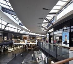 the interior of a shopping mall with people walking around