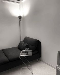 a black and white photo of a living room with a couch, coffee table and air conditioner