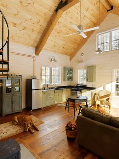 a dog laying on top of a wooden floor in a living room next to a kitchen