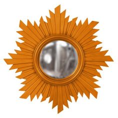 an orange star shaped mirror on a white wall