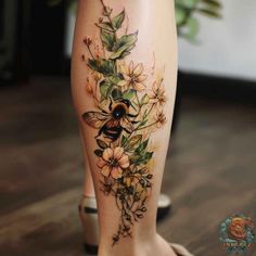 a woman's leg with flowers and a bee on it