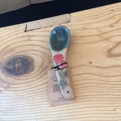 a wooden table with a spoon on it and a price tag attached to the spoon