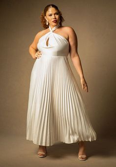 a woman in a white dress posing for the camera with her hands on her hips