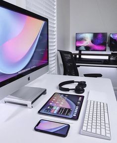 a computer desk with two monitors, keyboard and mouse on it in front of the monitor