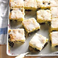 a pan filled with cake and frosting on top of a wooden table