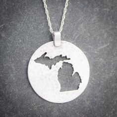 Flaunt your Michigan pride with this lovely sterling silver pendant.  Both peninsulas of Michigan are cut out of a large silver circle that has been textured to catch the light.This pendant measures approximately 1 1/8th inches in diameter, not including the bail.  Each pendant comes with a sterling silver chain at no extra charge. Please specify 16, 18, or 20 inches long for the chain.  If in doubt, 18 inch chains work well for most people. The pendant will come to you gift boxed, whether it is Etched Sterling Silver Round Pendant Jewelry, Etched Sterling Silver Round Disc Jewelry, Sterling Silver Coin Pendant Jewelry, Silver Circle, Metal Earrings, Metal Necklaces, Sterling Silver Chain, Sterling Silver Pendant, Sterling Silver Chains