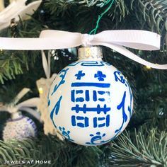 a blue and white ornament hanging from a christmas tree