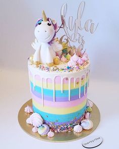 a birthday cake decorated with an unicorn and rainbow icing