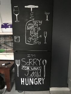 two black refrigerators with chalk writing on them