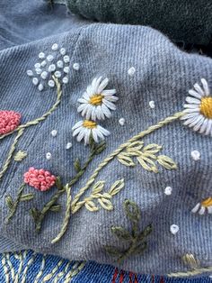 an embroidered piece of cloth with flowers on it