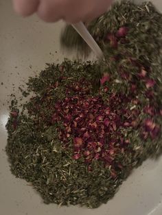 someone is sprinkling herbs into a bowl