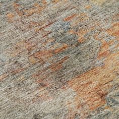 an orange and gray rug with different colors on the carpet is seen in this close up photo