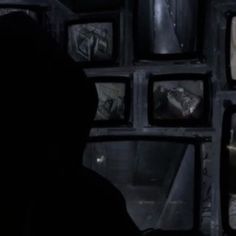 the silhouette of a person standing in front of televisions