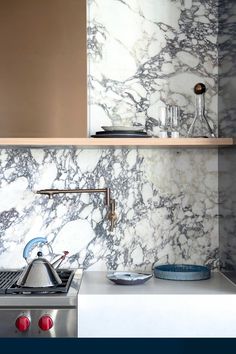 a stove top oven sitting inside of a kitchen next to a wall mounted faucet