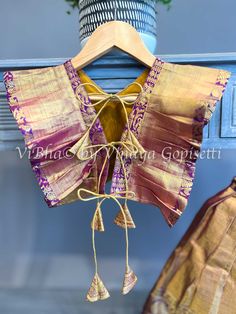 Stylish and unique, this Gold Tissue and purple Kanchi Silk Skirt and Top features a top with side ruffles and back dori handmade tassels. Perfect for cute girls, this outfit offers not only a comfortable fit, but also a one-of-a-kind style. Silk Skirt And Top, Indian Skirts, Fancy Clutch, Kids Wear Boys, Pleated Saree, Indian Skirt, Kids Wear Girls, Mens Sherwani, Silk Saree Banarasi