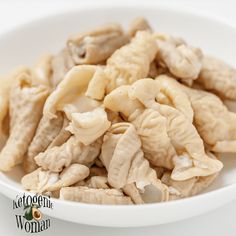 a white bowl filled with peeled and uncooked food items on top of a table