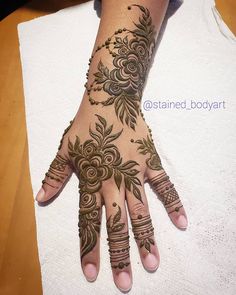 a woman's hand is decorated with hennap and flower designs on it