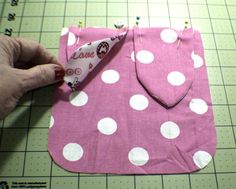 someone is making a pink and white polka dot bib