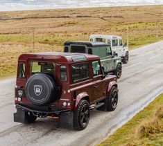 two jeeps are driving down the road