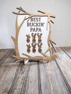 a wooden sign with deer heads on it that says best buckin'papa