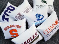 six pillow cases with college logos on them are arranged in a circle together to form the shape of a heart