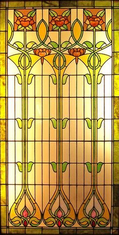 a stained glass window with flowers and leaves on it's sides, in the middle of