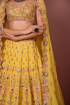 Yellow lehenga highlighted intricate floral embroidery. Comes with sweetheart neckline blouse and cutwork dupatta.
Components:3
Embroidered
Neckline:Sweetheart
Sleeve Length:Sleeveless
Fabric:Georgette
Color:Yellow 
Aztek, resham, dori, foil, mirror and gota embroidery
Embroidered blouse and cutwork dupattaCrepe lining - Aza Fashions Yellow Floral Embroidered Sharara For Reception, Reception Yellow Floral Embroidered Sharara, Yellow Floral Embroidery Sharara For Reception, Designer Yellow Lehenga With Floral Embroidery, Yellow Choli With Floral Embroidery For Reception, Yellow Floral Embroidered Lehenga For Wedding, Yellow Semi-stitched Lehenga With Motifs, Semi-stitched Yellow Lehenga With Motifs, Designer Yellow Choli With Motifs