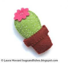 a small green cactus with a pink flower on it