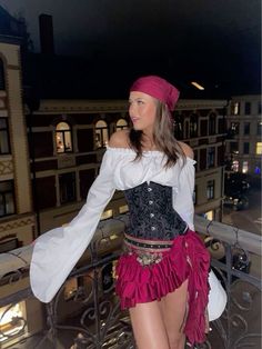 a woman in a corset is standing on a balcony