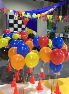 a room filled with lots of balloons and cones