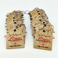 wooden house keychains with business cards attached to them