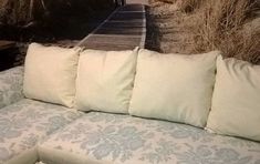 a couch with four pillows on it in front of a wall that looks like a railroad track