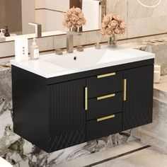 a bathroom sink sitting under a mirror next to a wall mounted faucet with flowers on it