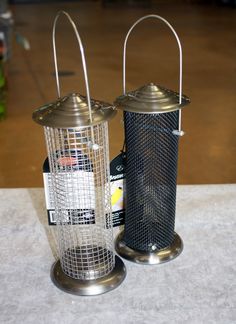 two metal lanterns sitting on top of a table