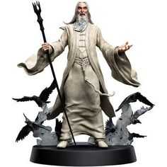 a statue of an old man with white hair and beard holding a staff, surrounded by birds