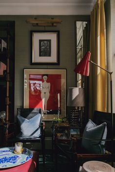 a living room filled with furniture and pictures on the wall next to a table covered in plates