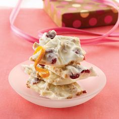 a stack of food sitting on top of a white plate next to a pink ribbon