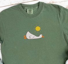 Comfort Colors Embroidered Goose Tshirt, Silly Goose Lying Under The Sun.MADE IN USA If you are interested in adding embroidery to the sleeve please go to this listing: www.etsy.com/listing/1743253563 Because it is made to order, we don't accept the return or exchange unless we make a mistake We are unable to replace or refund purchases based on the color and the font selections. Please make sure to be very specific and make the correct selections when you place an order. Please feel free to rea Funny Vacation, Embroidered Tote Bag, Silly Goose, Embroidered Tote, Sun Shirt, Comfort Colors, Favorite Outfit, Made In Usa, The Sun