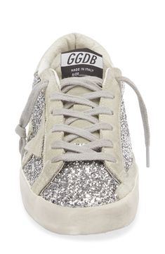 Shimmering glitter brings a dazzling finish to a skate-inspired sneaker, hand-distressed and scuffed for an instant worn-in look. Lace-up style Synthetic, textile and leather upper/leather and textile lining/rubber sole Made in Italy Designer Shoes Silver Glitter Sneakers For Streetwear, Metallic Low-top Sneakers With Glitter Accents, Sparkling Low-top Sporty Sneakers, Sporty Low-top Sparkling Sneakers, Sporty Sparkling Low-top Sneakers, Sparkling Low-top Sneakers For Streetwear, Golden Goose Deluxe Brand, Super Star, Golden Goose